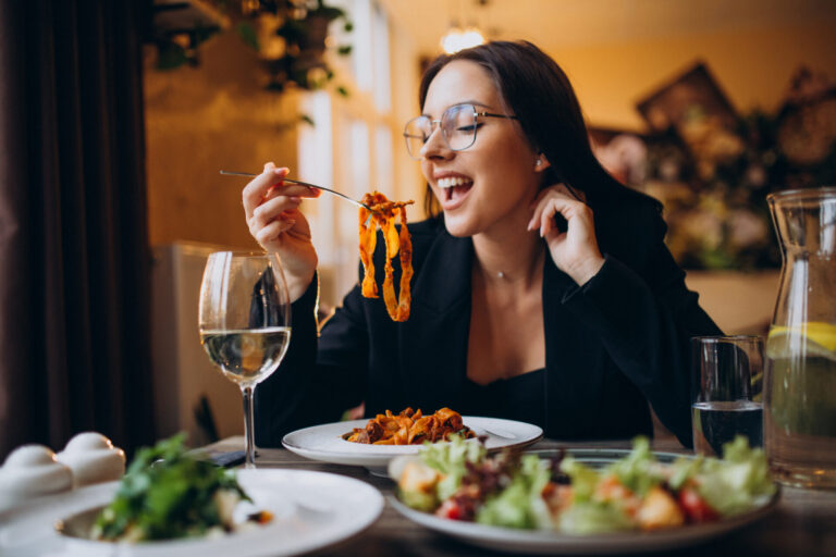 Young woman eating pasta in a cafe